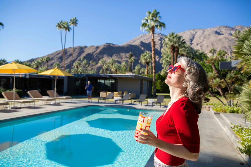 women with glass by pool at the Dinah shore estate