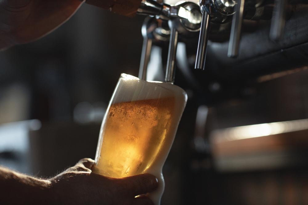 Man pouring a beer from a tap in a bar.