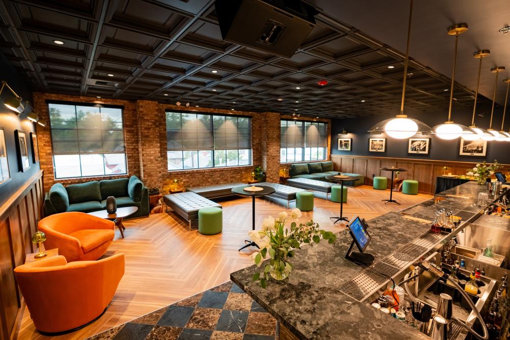 Studio 24 lounge inside Channel 24, featuring a stylish bar, lounge seating, and a modern, upscale interior with brick walls and large windows.
