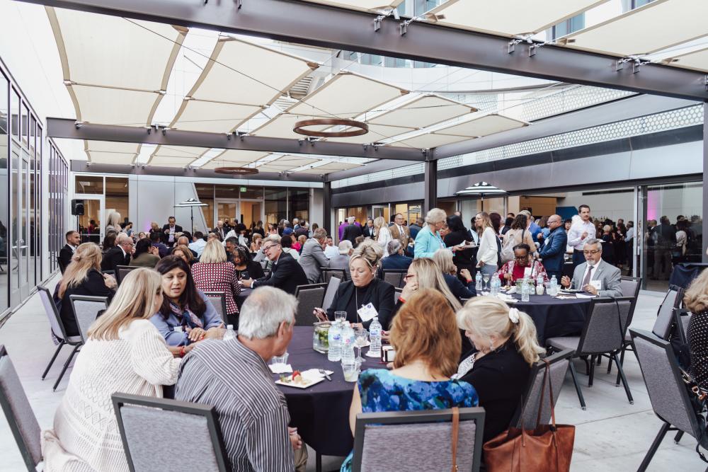 people sitting at tables on the outdoor terrace at the safe credit union convention center