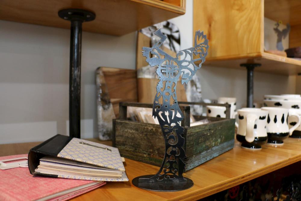 A miniature Keeper of the Plains sits on a desk at The Workroom