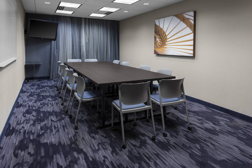 Chairs are set up around a table in a boardroom at Fairfield Inn and suites downtown