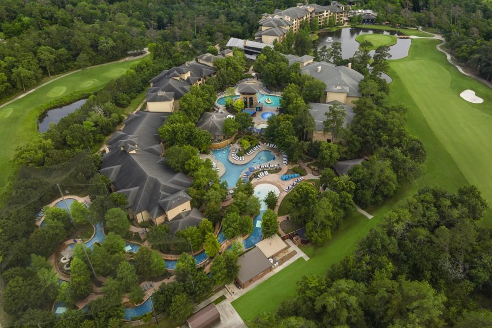 An aerial photo of The Woodlands Resort hotel, pool, lazy river, and various golf courses.