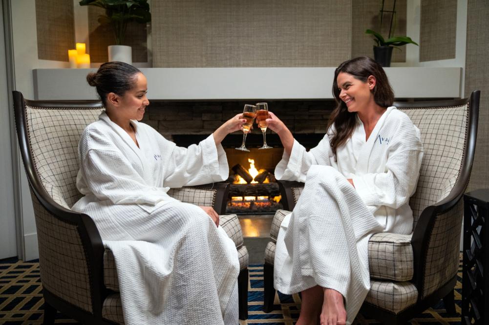 Two women by the fire having wine at a Avani Spa