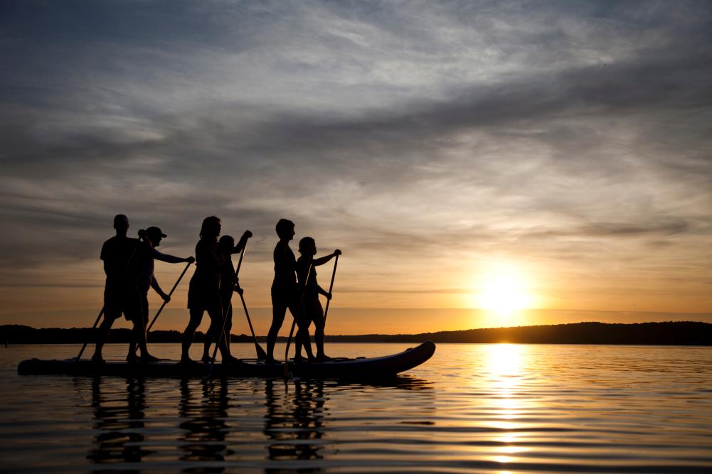 Family paddle boarding at sunset on Geneva Lake