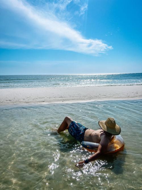 A gentleman relaxes and unwinds on the beach on Cape San Blas in a tide pool.