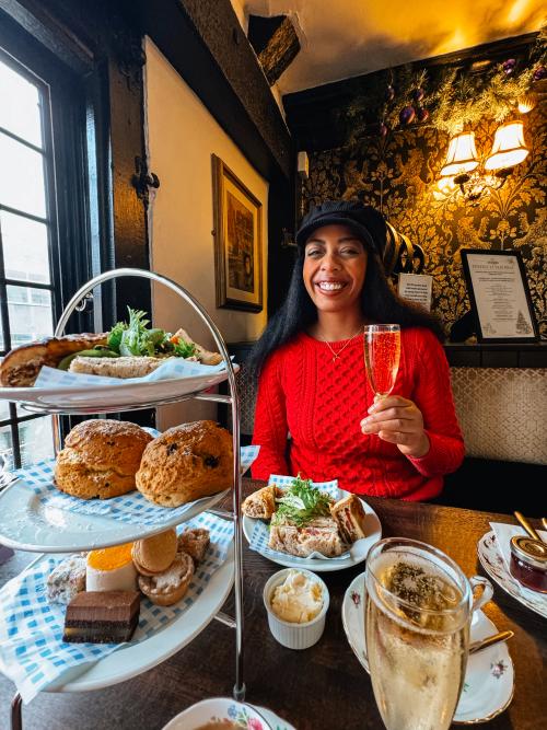 A woman sat enjoying an elaborate afternoon tea.