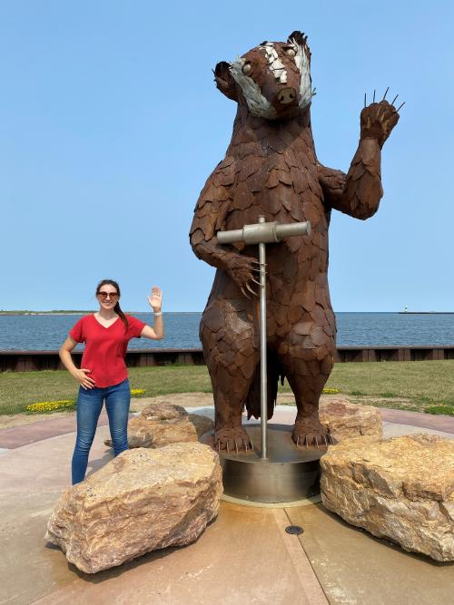 Woman waving like Shipbuilder the Badger sculpture in Manitowoc Wisconsin