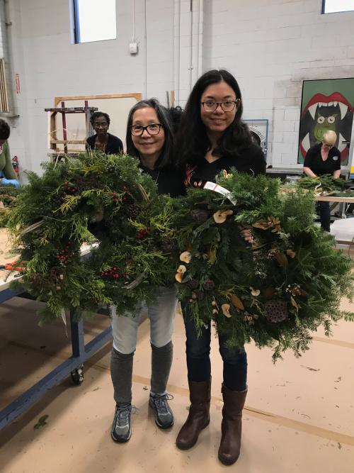 Two girls holding wreaths