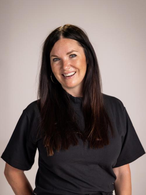 Smiling woman wearing a black polo shirt