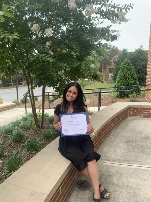 Destine Lalas poses smiling with her STS Marketing College certificate