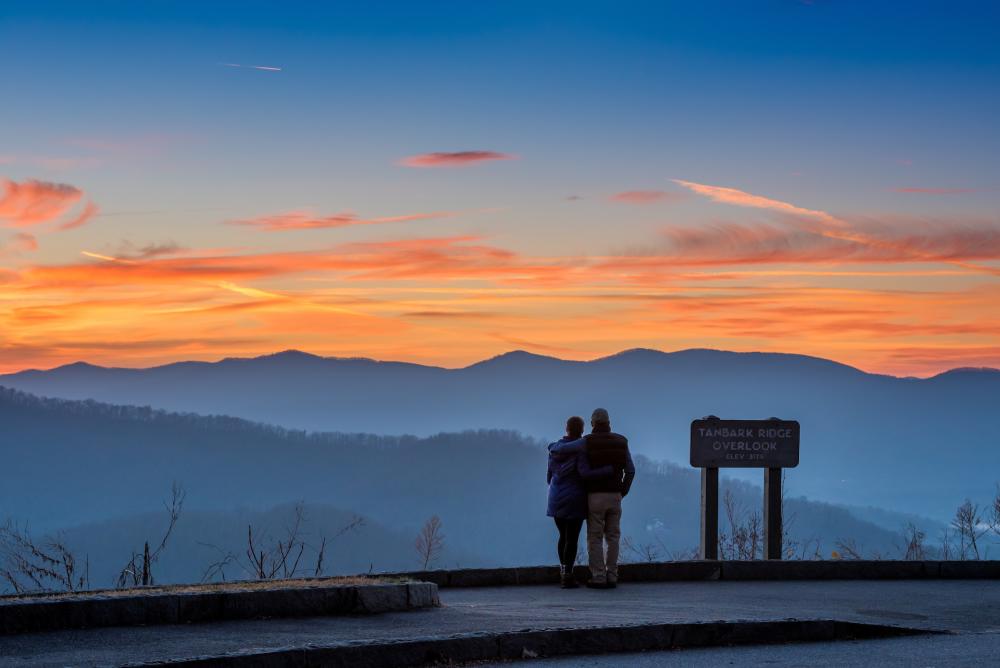 A couple enjoys a mountain vista on the Blue Ridge Parkway near Asheville, NC