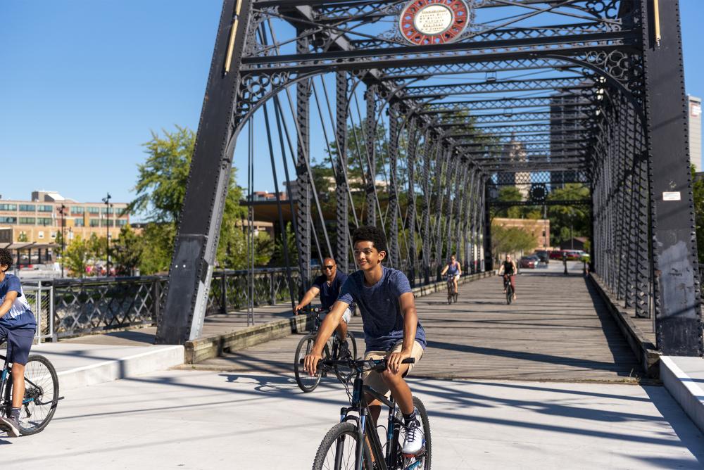 Family biking across the wells street bridge at promenade park