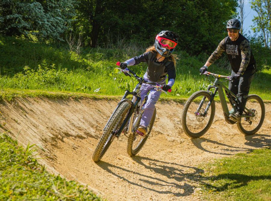 Two people on bikes following a track at the FlyUp 417 Bike Park