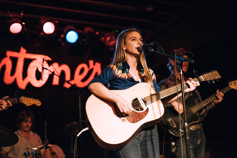 Kathryn Legendre playing acoustic guitar at Antones