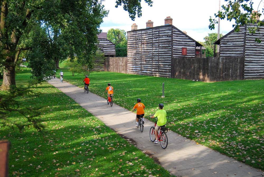 Family biking along Fort Wayne's downtown trails near the Old Fort