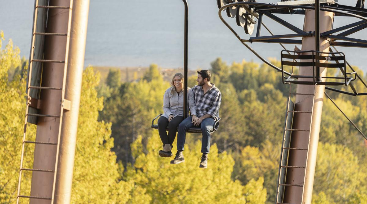 A couple enjoying a fall color chairlift ride