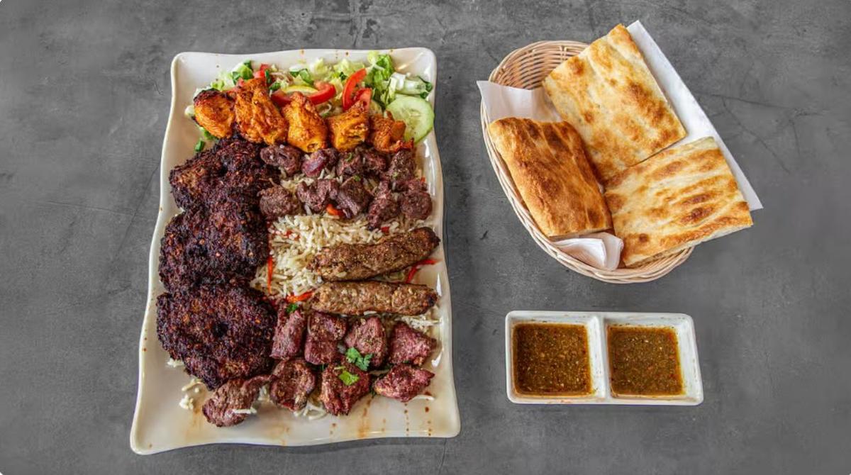 A picture of the family combo at Afghan Kebab House, which includes a mix of kebabs, rice, salad, naan and chutney.