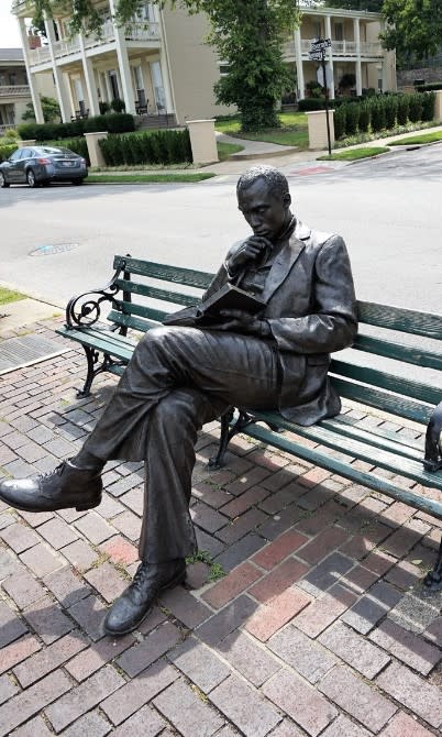 Image is of the bronze statue of James Bradley sitting on a bench, reading a book.