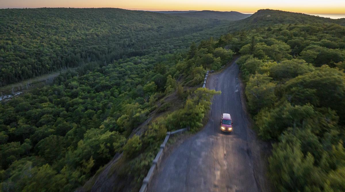 Aerial view of car driving along Brockway Mountain Drive at dusk