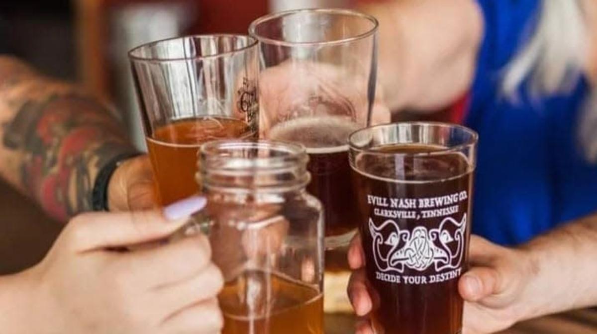 four people holding glasses of beer in a cheer