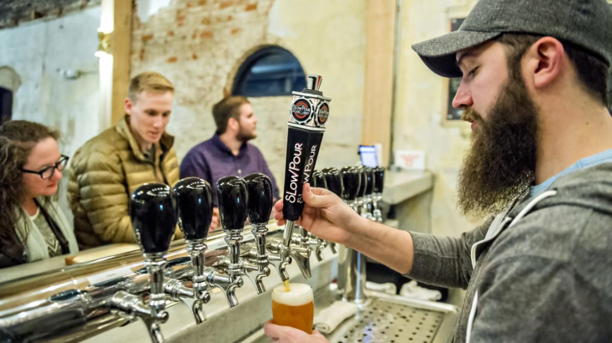 man pouring beer from tap