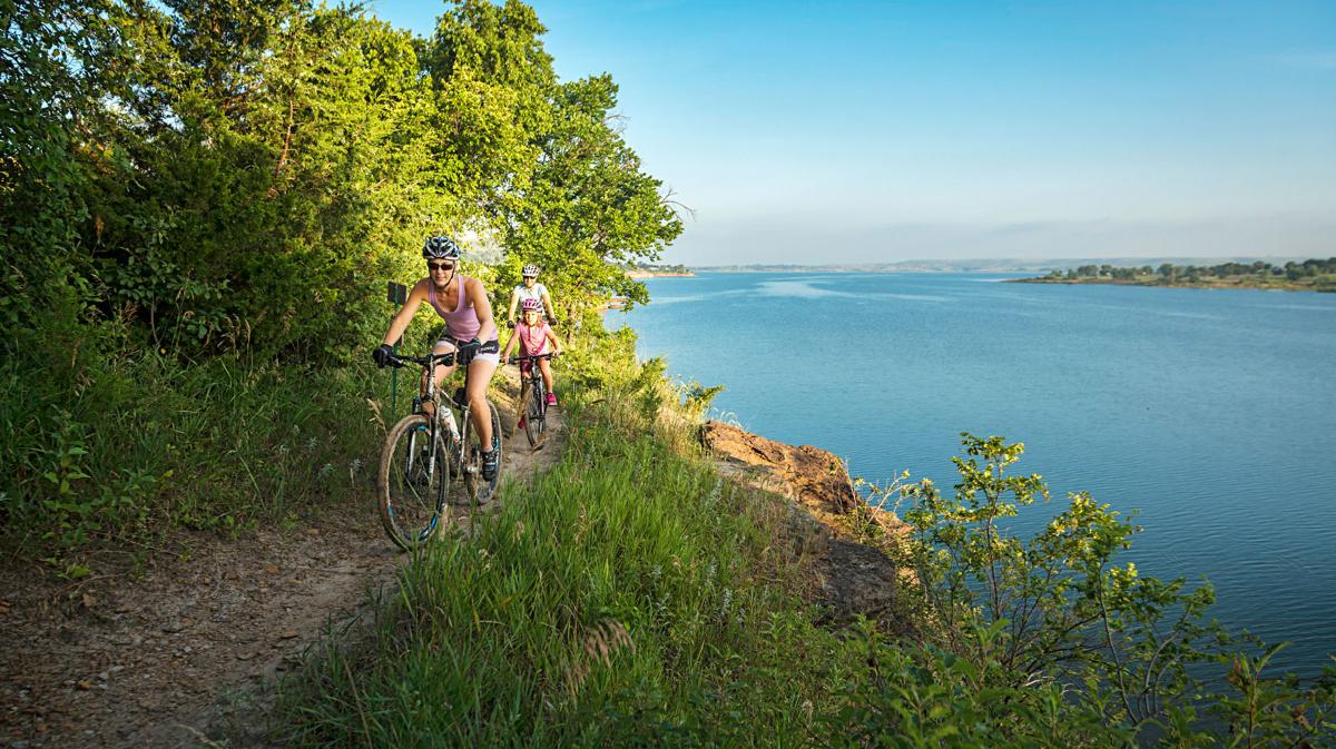 mom and daughter biking around a lake