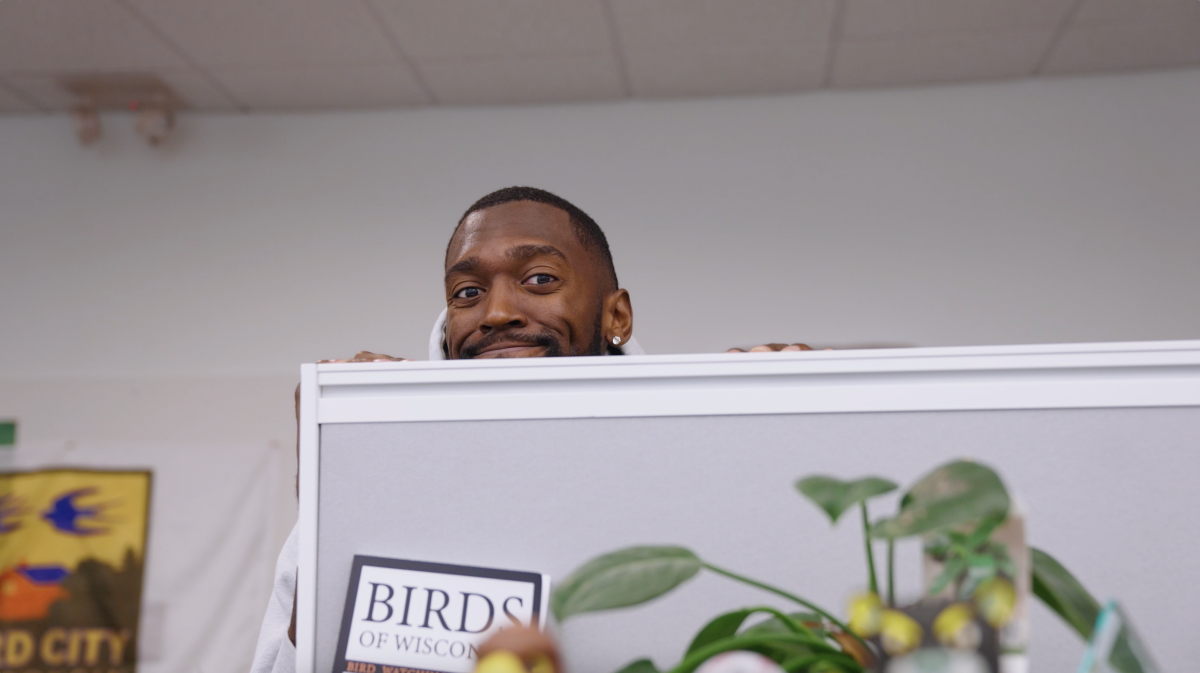 Bobby Portis peaking over the top of a grey cubical wall