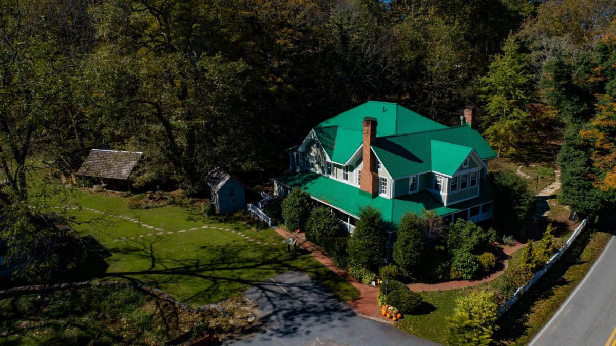 A green roofed house is seen from above.