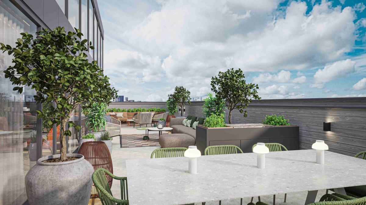 Private penthouse terrace at The Medlock hotel featuring outdoor seating, dining table and chairs, and landscaped planters, with city views and a bright sky backdrop.
