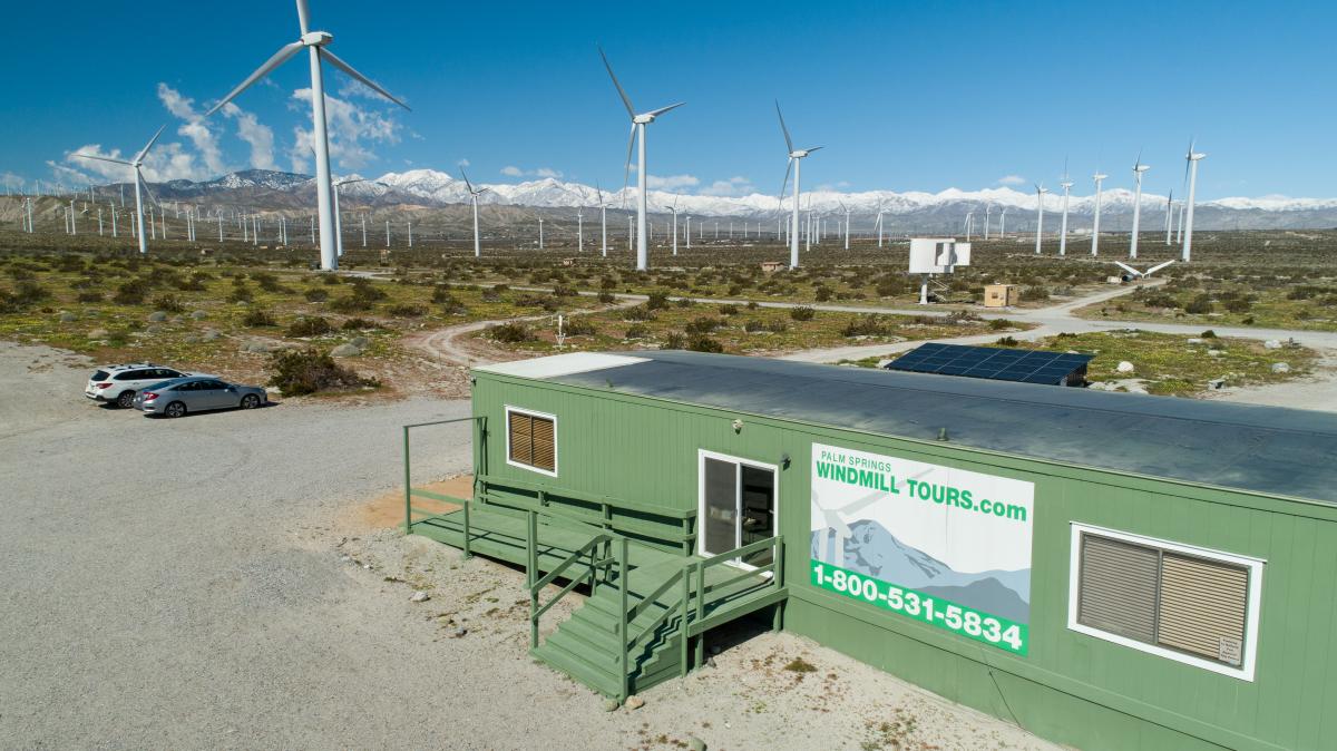 The office of Palm Springs Windmill Tours sits amid a windmill farm with wind turbines in the background.