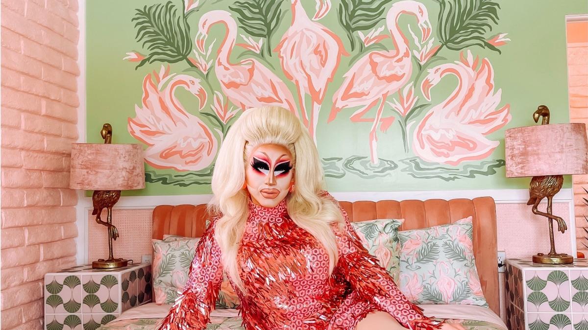 Drag Queen Trixie Mattel sits on a bed in her Trixie Motel in Palm Springs