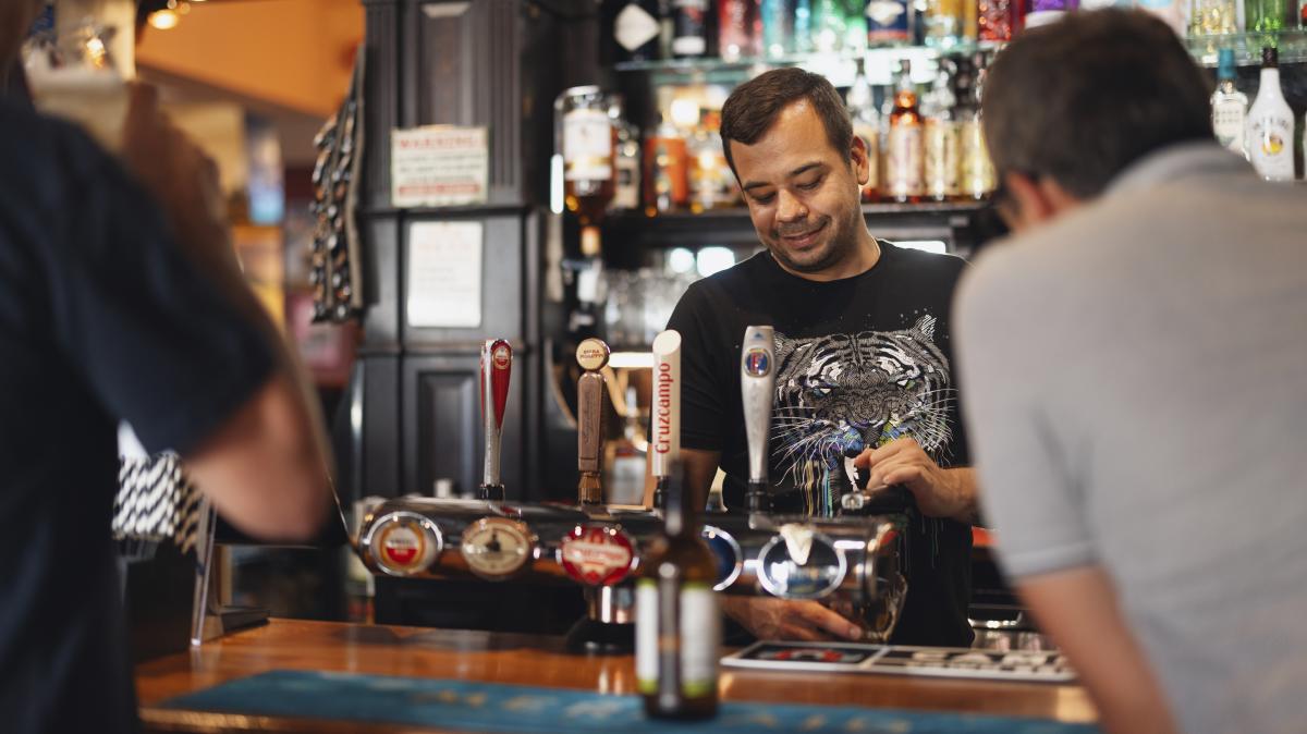 Bartender pouring drink on tap at The Grapes