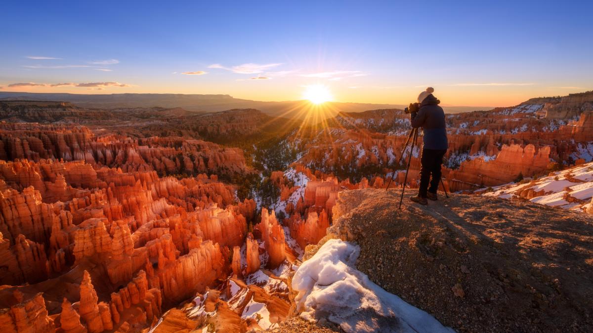 Photographer taking photos of Bryce Canyon National Park at sunset in the wintertime