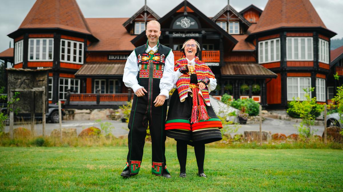 En kvinne og en mann i Setesdalsbunad foran Sølvgarden hotell
