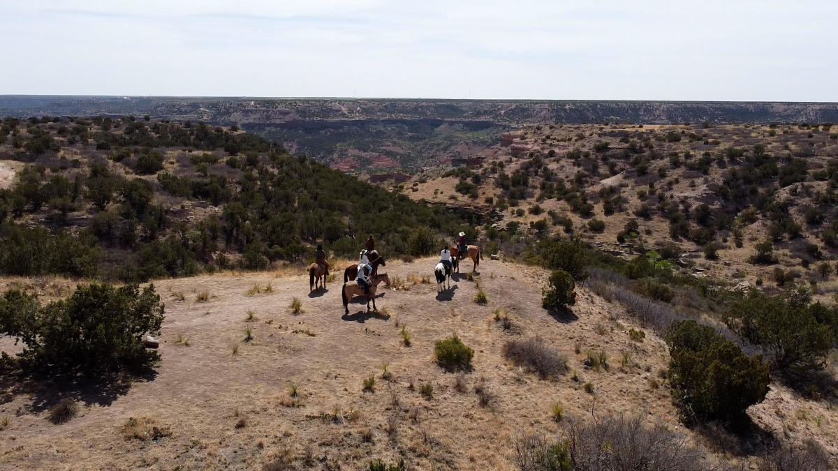 Group of people riding horseback in Los Cedros Ranch