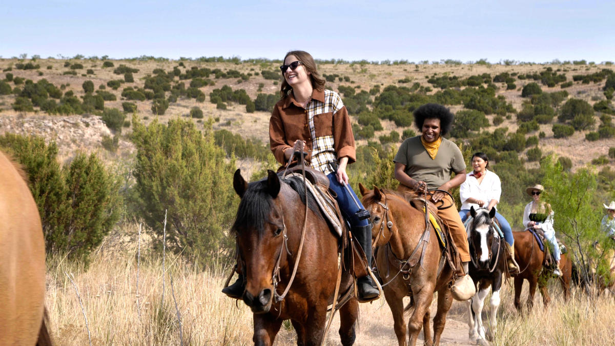 group of people horseback riding smiling