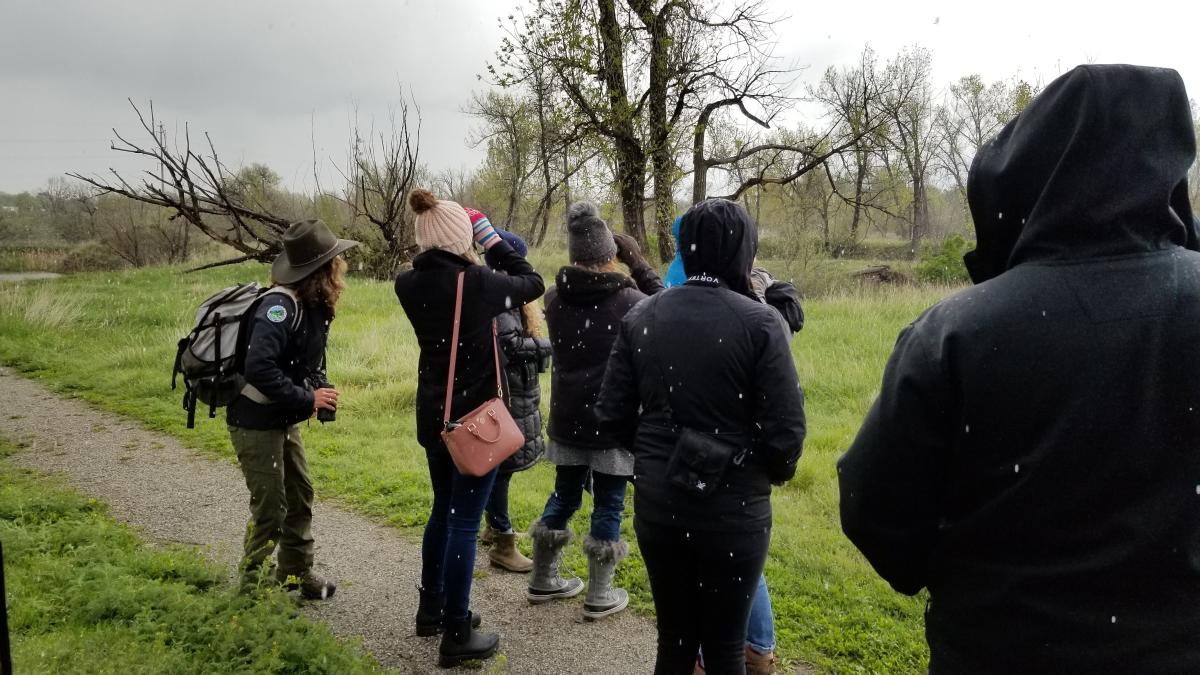 Group looking through binoculars for birds at Sawhill Ponds at snow flurry comes down