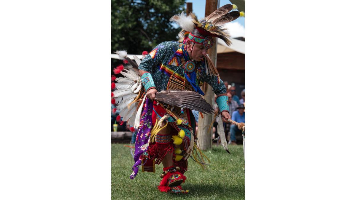 Male dancer in detailed beadwork and eagle feathers engaging with the crowd during a performance at Morning Star American Indian Village in Cheyenne.