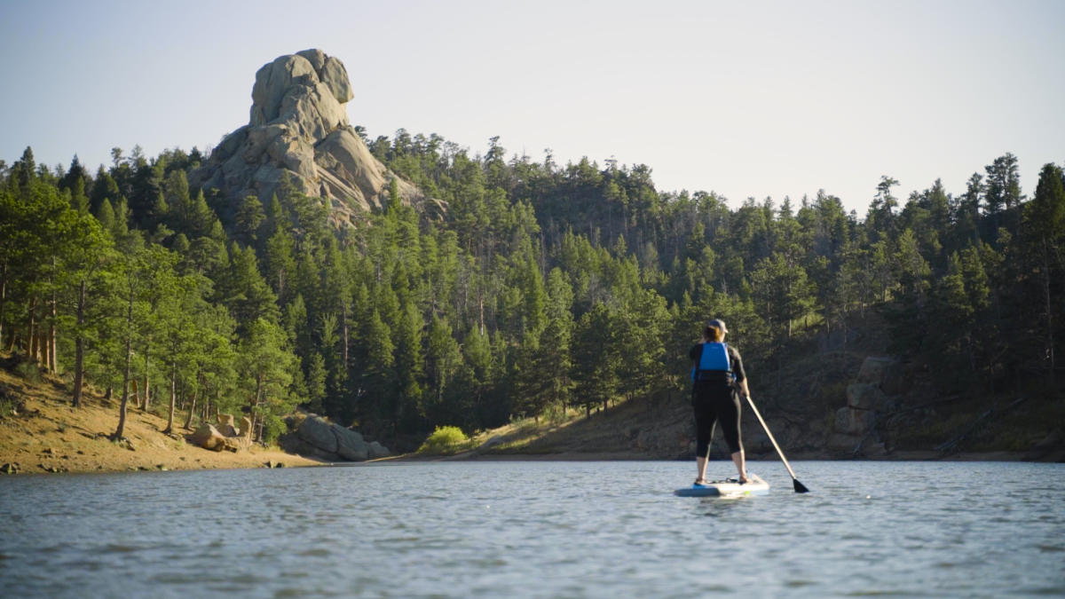 A woman paddle boards in Curt Gowdy State Park, a top RV camping destination.