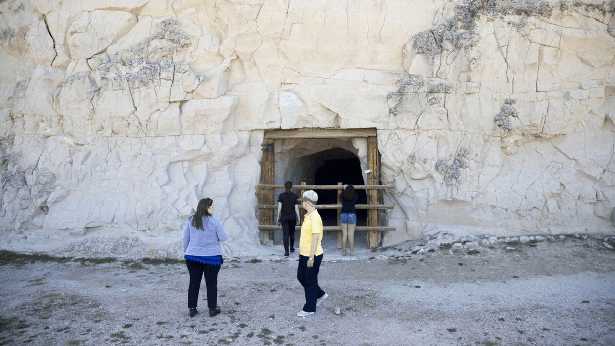 Visitors at the base of the Register Cliff Historic Site.