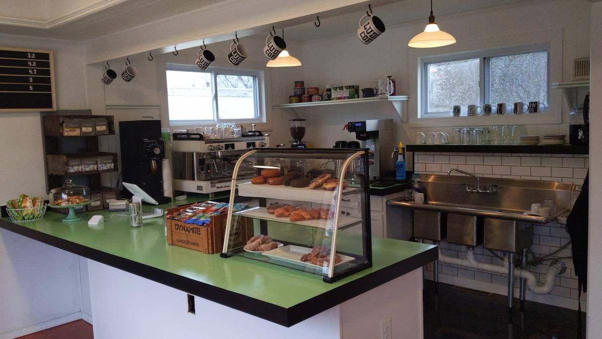 Image is of the counter at Ludlow Coffee with a display of pastries and snacks.