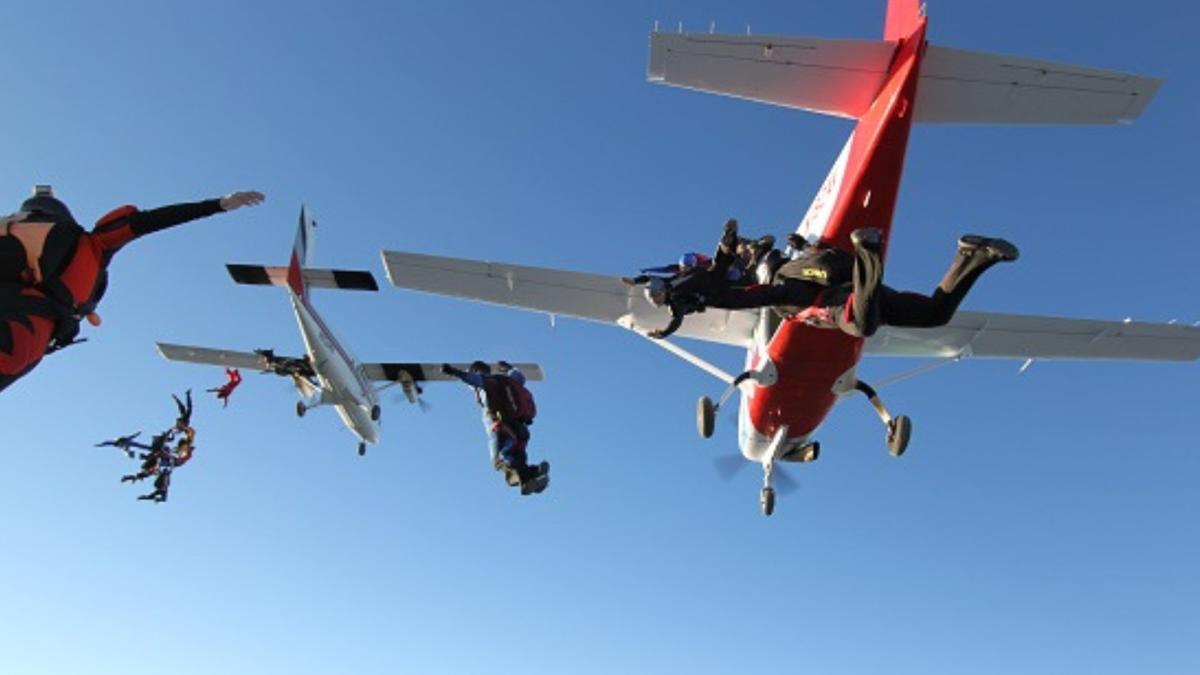 people skydiving from two airplanes in the sky