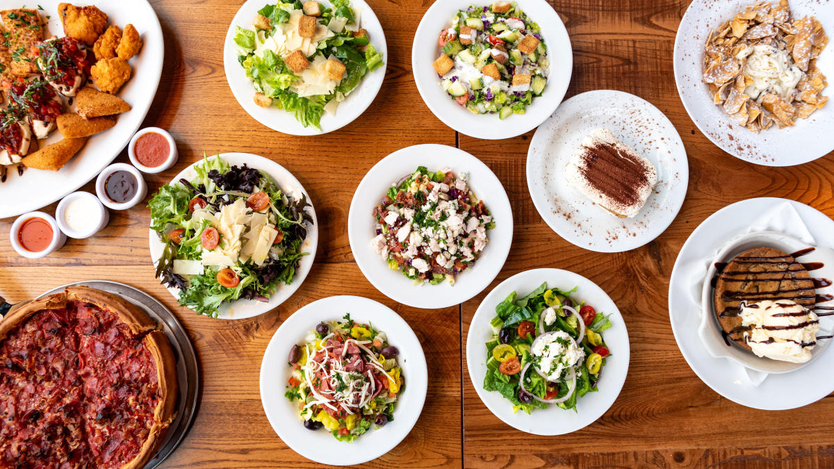 A full table of Italian food, including Pizza, salad, appetizers, and dessert. At Giordano's in Fort Wayne