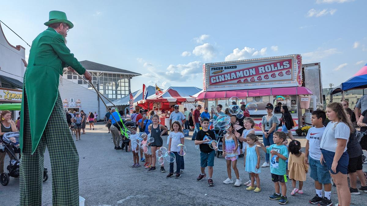 children at fair, man on stilts