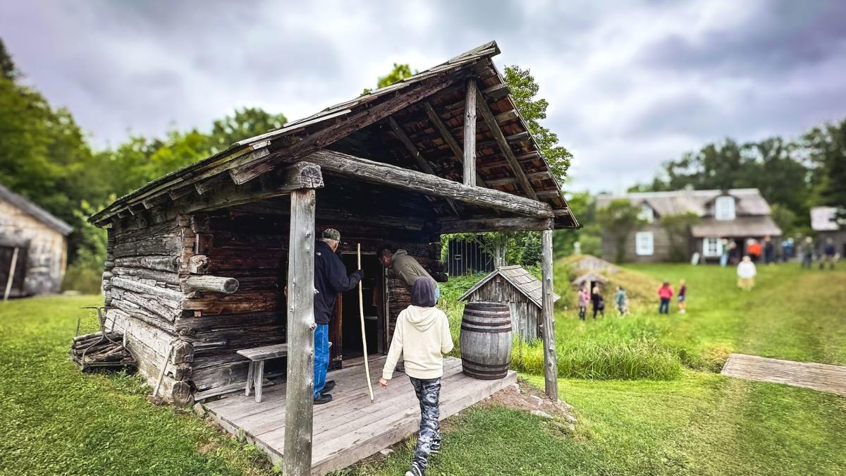people walk into a rustic historic cabin