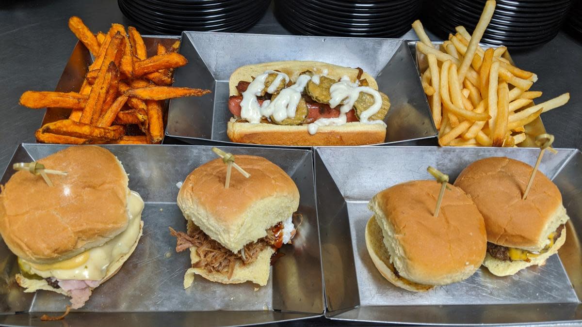 Sweet potato fries, small slider burgers all on separate metal trays