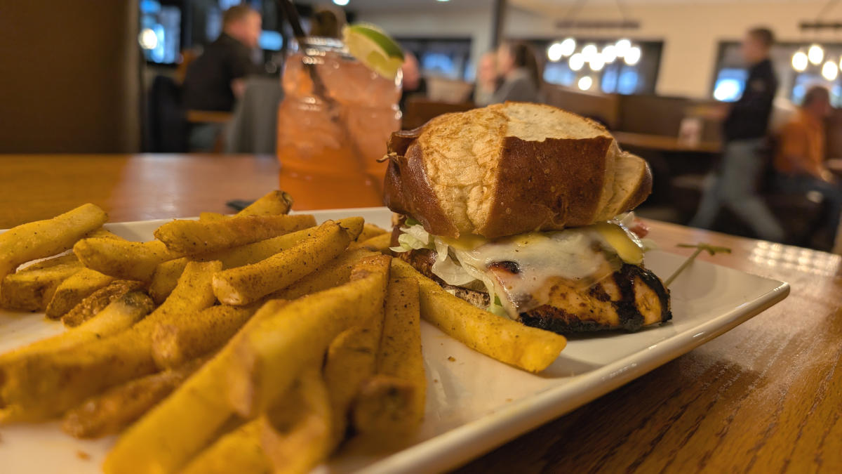 Burger and steak fries on a plate with a pink drink