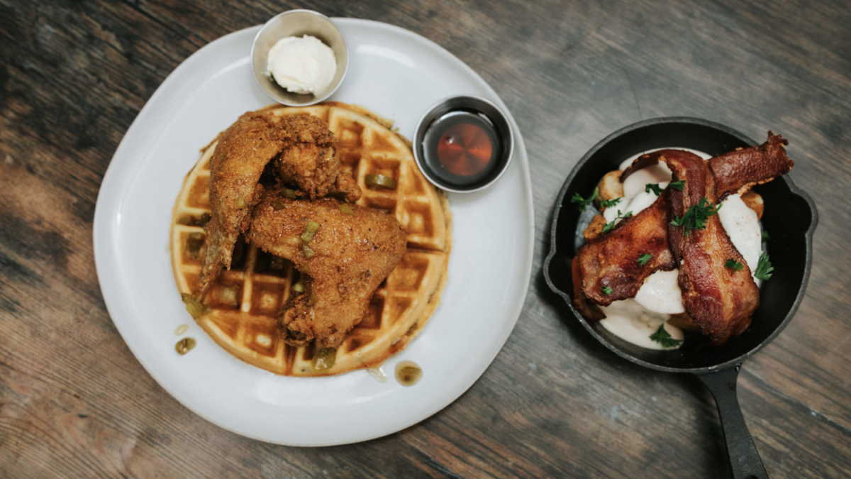 Overhead shot of food with chicken and waffles, bacon and eggs