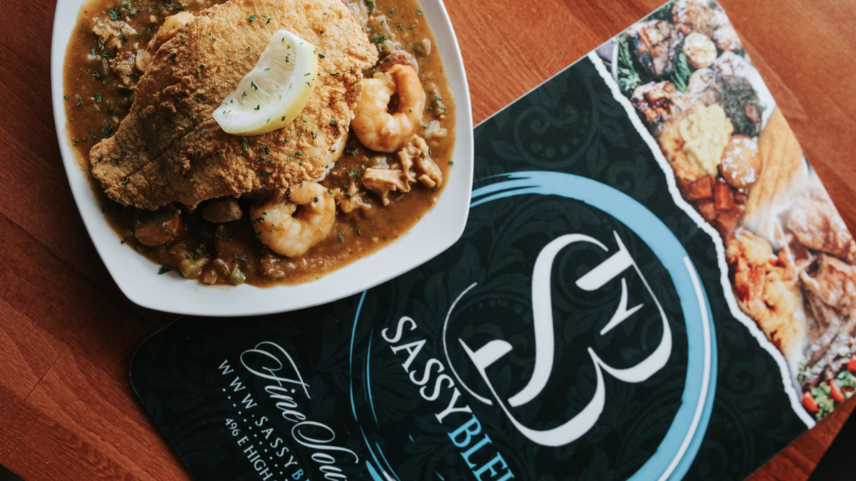 Plate of fried fish and shrimp with Sassy Bleu menu on table